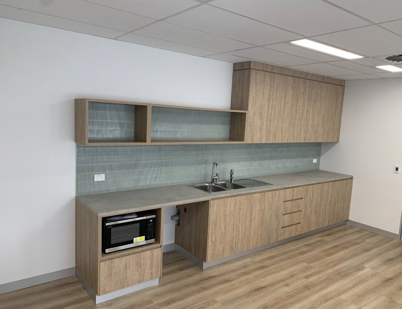 Compact Kitchenette with Green Tile Splashback — Cabinets by Oaktree custom cabinetry
